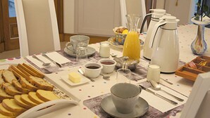 A breakfast table set with bread, butter, coffee, and juice. - Chez Bernadou (Machecoul-Saint-Même)
