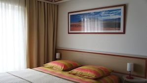 A hotel room with a bed, a nightstand, a lamp, and a framed picture on the wall. - Chez Bernadou (Machecoul-Saint-Même)