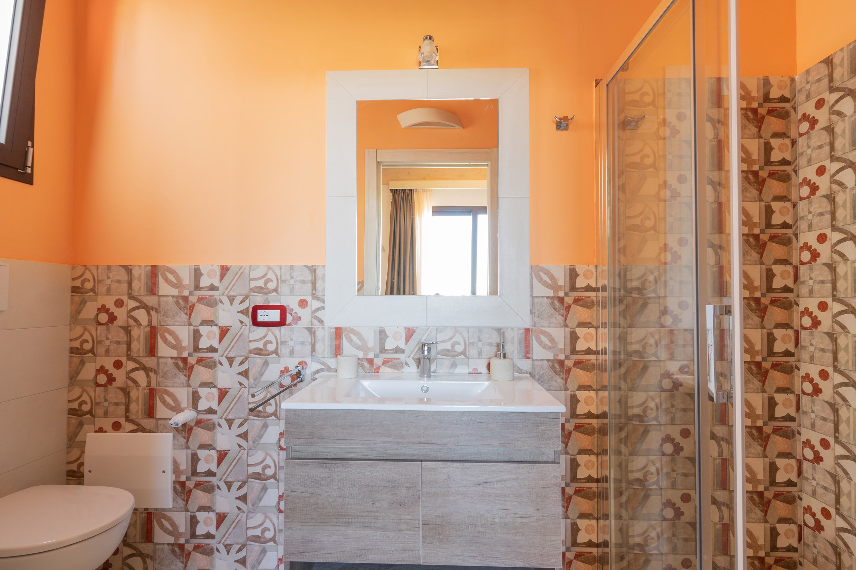 A bathroom with a toilet, sink, and shower.