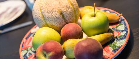 A plate with various fruits including apples, pears, and a melon.