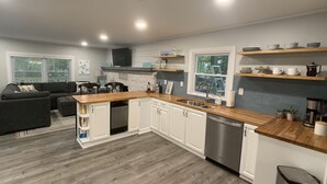 A modern kitchen with white cabinets, a stainless steel dishwasher, wooden countertops, and a built-in oven. - Restful River House-private dock- on a golf course-5 mins to downtown Kilmarnock (Kilmarnock)