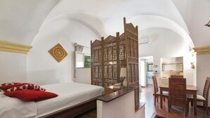 A bedroom with a bed, red pillows, a wooden partition, a desk, and chairs. - 3036 Salotto Barocco by Barbarhouse (Lecce)