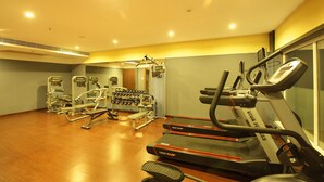 A gym with treadmills, weight machines, and dumbbells. - The Garuda Hotels (Thrissur)