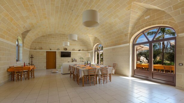A spacious dining area with a high arched ceiling and large windows. - 2283 Villa La Paiara by Perle di Puglia (Melendugno)