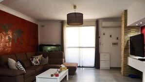 A modern living room with a brown sofa, white coffee table, and a world map on the wall. - Modern and Homely Apartment in Marsaskala (Marsaskala)