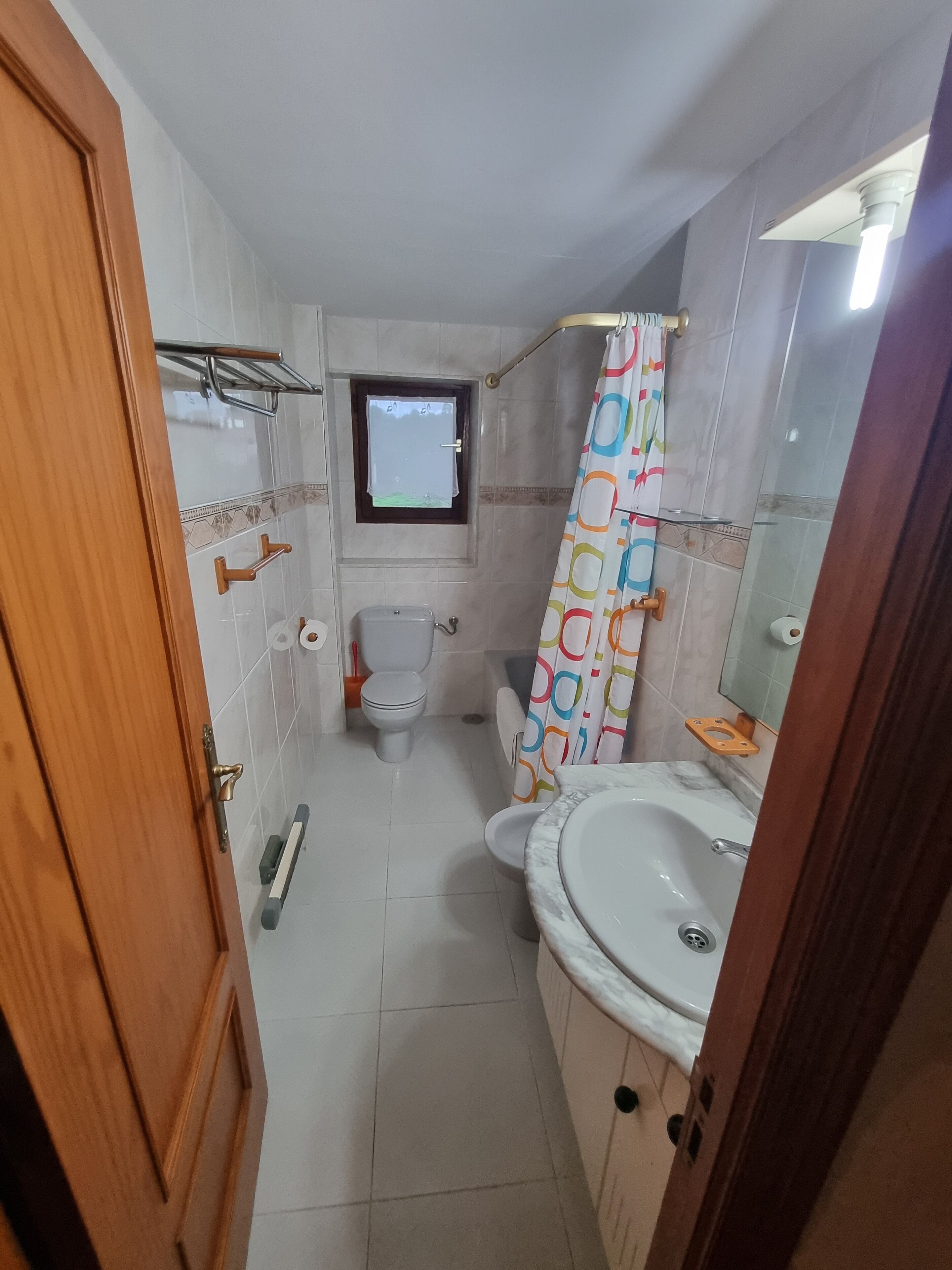 Un baño pequeño con inodoro, bidé y lavamanos.