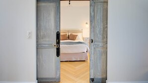 A bedroom with a bed, a nightstand, and a wall-mounted light fixture.