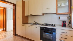 A modern kitchen with white cabinets, a gas stove, an oven, and a sink. - 2864 Villa Carminella by Barbarhouse (Lecce)