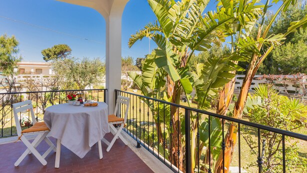 A balcony with a table and chairs, surrounded by tropical plants and a clear view of the surrounding area. - 2864 Villa Carminella by Barbarhouse (Lecce)