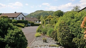 A residential street with a house, a driveway, and surrounding greenery. - Mount Sol (Ambleside)