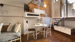 A compact kitchen with a dining table, chairs, and a built-in bench. - 2417 Dimora Santa Croce by Barbarhouse (Lecce)