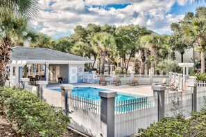 A pool area with a white fence, lounge chairs, and palm trees. - Beach Daze of 30A. Golf Cart! Newly Renovated, 4 Bikes, & Community Pool! (Santa Rosa Beach)
