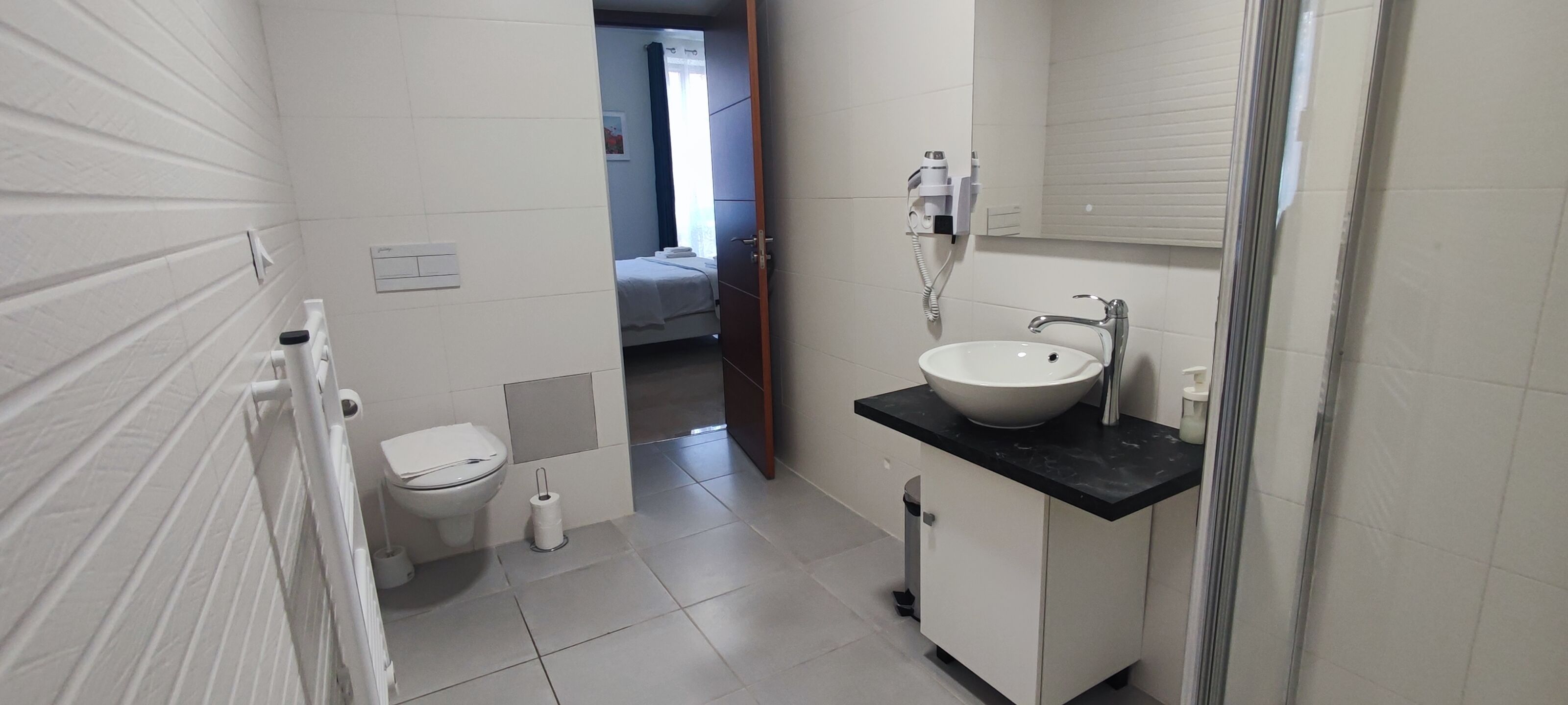 Ein Badezimmer mit Toilette, Waschbecken und Dusche.