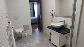 Ein Badezimmer mit Toilette, Waschbecken und Dusche.