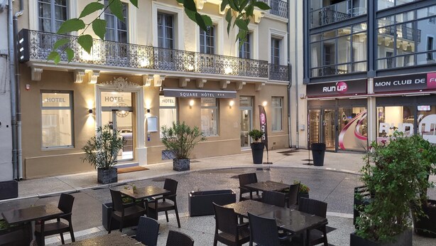 A hotel with outdoor seating and a balcony. - Square Hôtel (Nîmes)