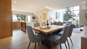 Una cucina moderna con zona pranzo, mobili in legno e un'ampia finestra.