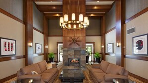 A lobby with two sofas, a central fireplace, and a chandelier. - MAGNIFICENT SKI-IN/OUT 1BR: AC and Gym (Whistler)