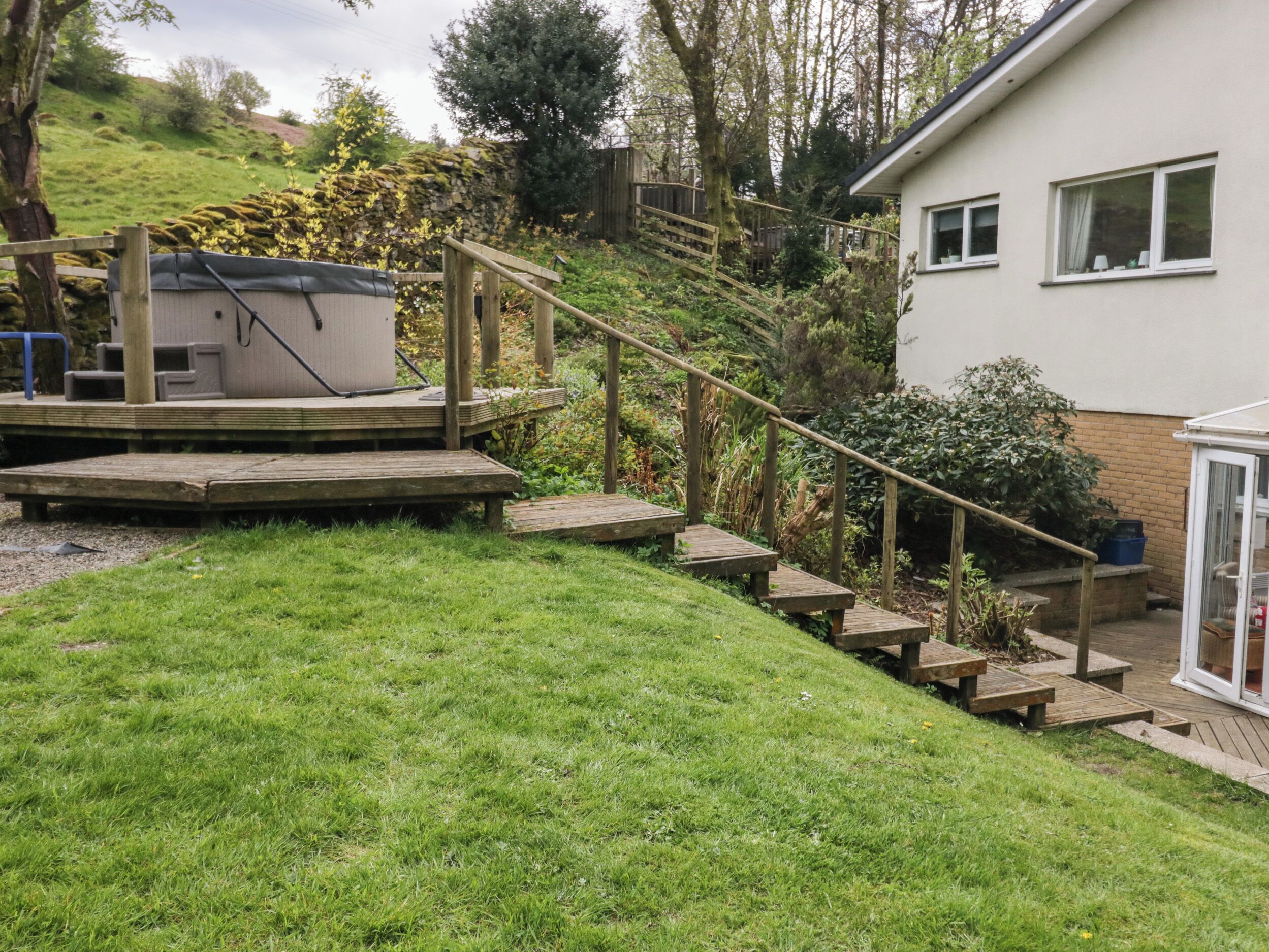 A wooden deck with steps leading to a house.