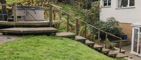 A wooden deck with steps leading to a house.