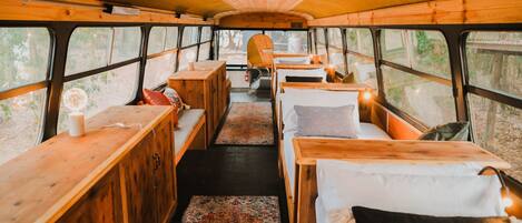 A cozy interior with wooden furniture, a central table, and benches along the sides.
