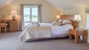 Una camera da letto con un letto, due comodini, una scrivania e una sedia.