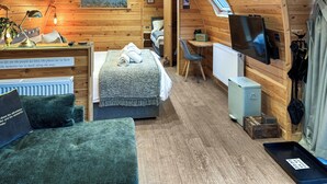 A cozy cabin interior with a bed, desk, and TV. - Lakeview Lodge- UK40692 (Crowhurst)