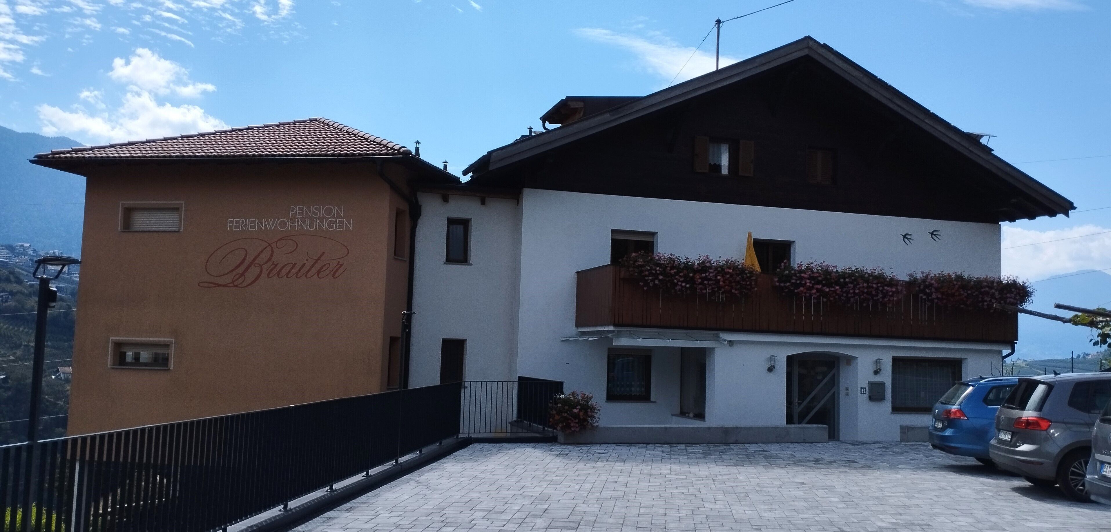 A two-story building with a sign reading 'Pension CHIMMINGER Braiter.'