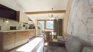 Une cuisine moderne avec des meubles en bois, un coin repas comprenant une table et des chaises, et un canapé.