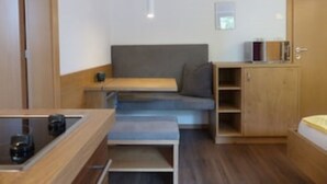Une pièce de taille modeste comprenant un lit, un petit bureau et une banquette intégrée.