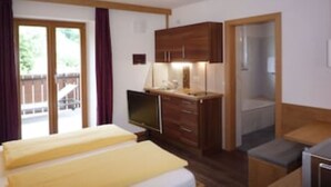 Une chambre avec un lit, un bureau, une télévision et une armoire.