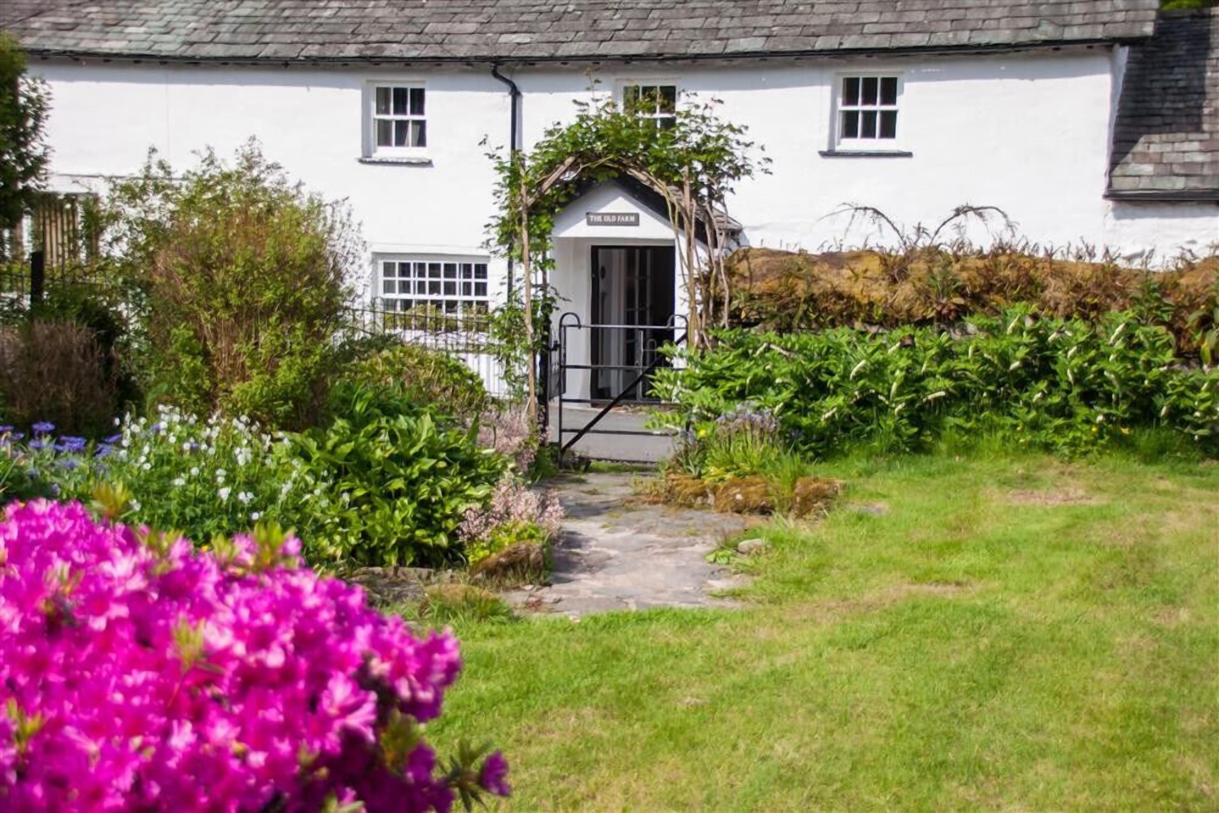 Un edificio blanco con un letrero que dice "The Old Farm".