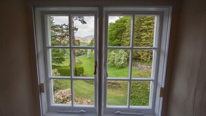 A window with a view of a green landscape, including trees and a lawn. - The Old Farm (Ambleside)