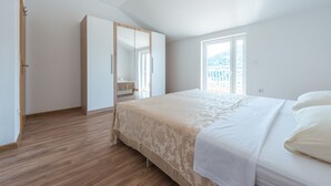 Een slaapkamer met een groot bed, een kledingkast en een raam met uitzicht.