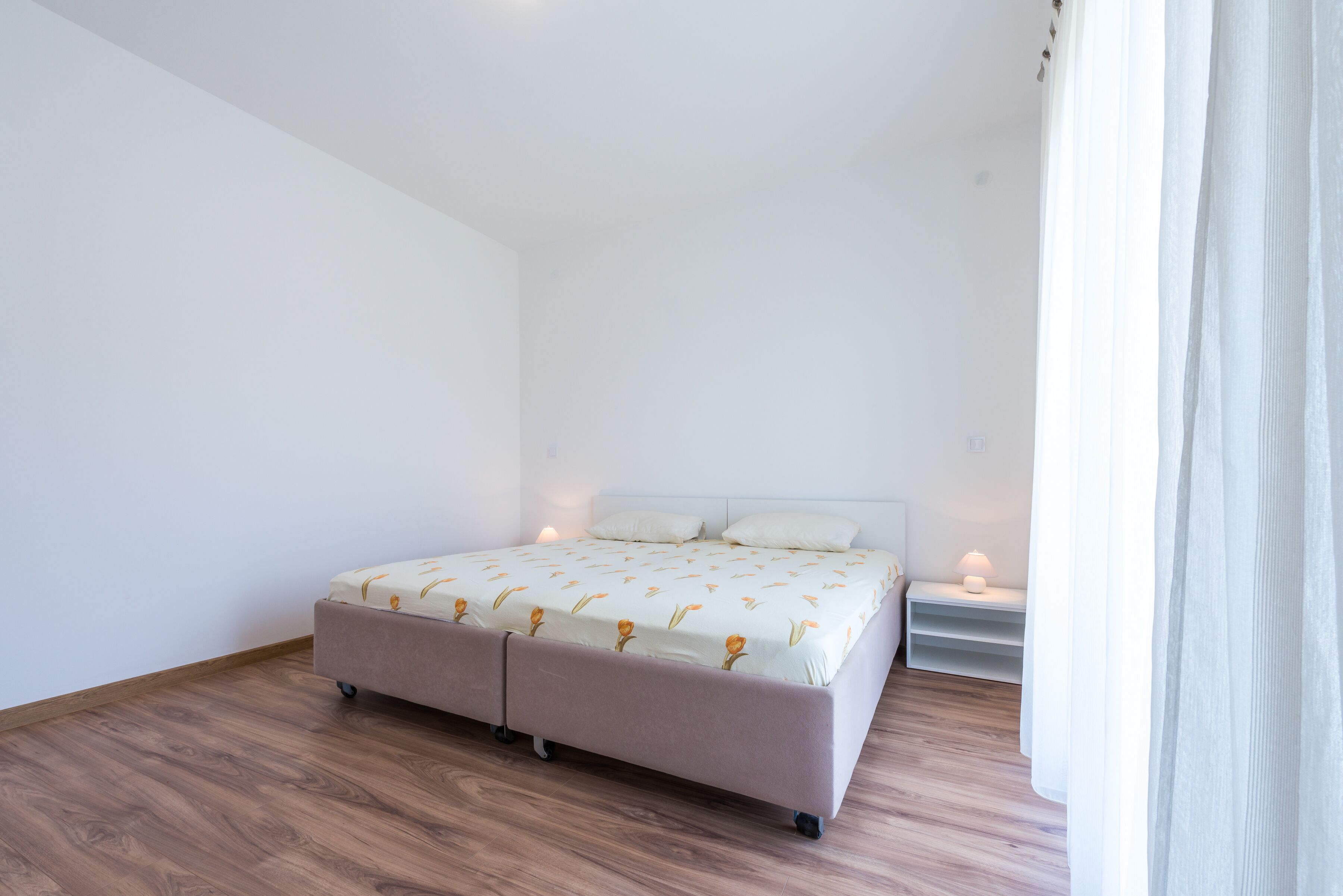 A bedroom with a bed, two bedside tables, and a nightstand.