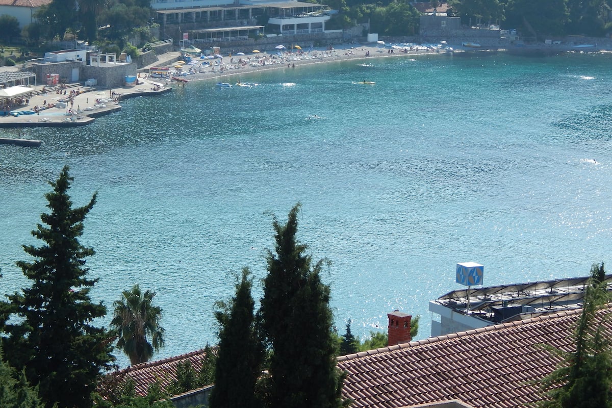 Eine Küstenlandschaft mit Strand, Gebäuden und blauem Meer.