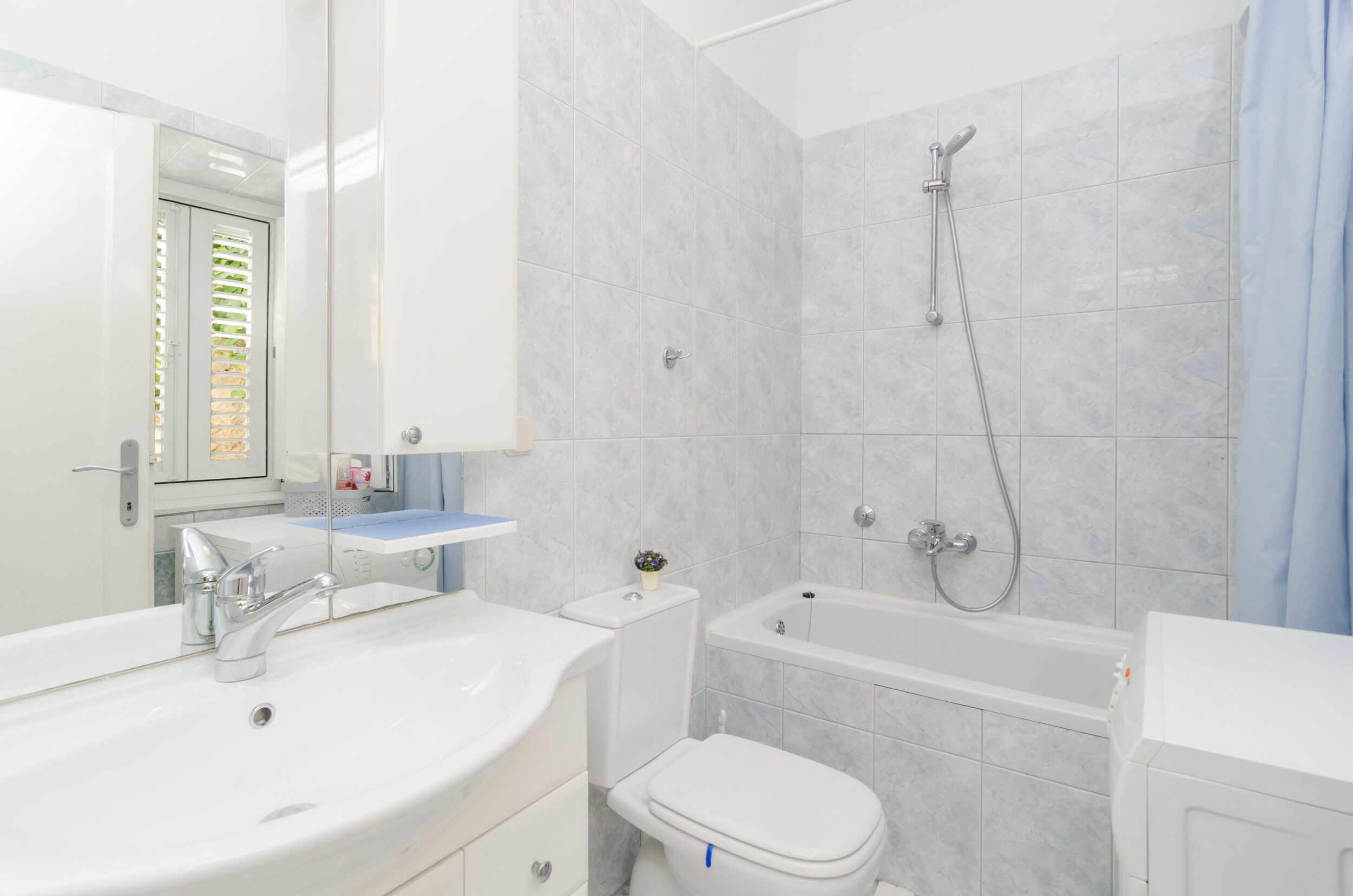 A modern bathroom with a sink, toilet, and bathtub.