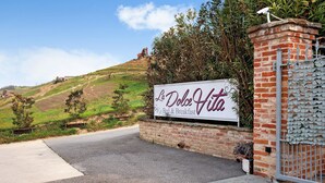 A sign for 'La Dolce Vita' with a view of a hill and construction in the background.
