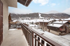 A balcony with a view of a snow-covered village and mountains. - Holiday Apartment "Vacanze Matteo" with Mountain View, Balcony & Wi-Fi (Livigno)