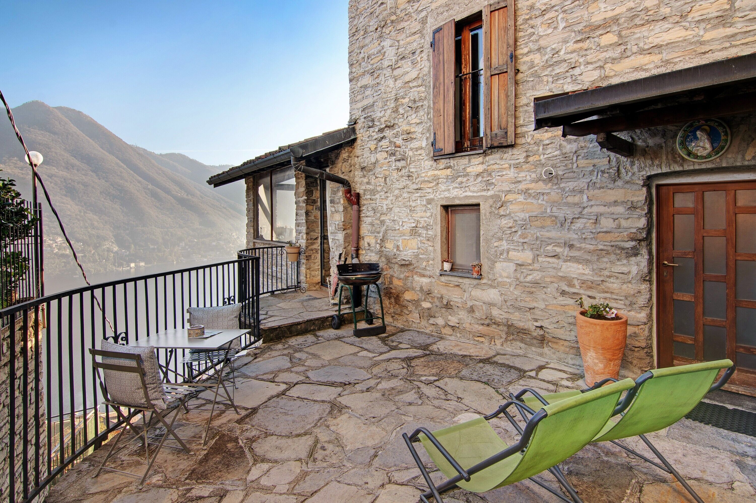 Ein Steinhaus mit Balkon, Außenbereich und Bergblick.