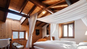 Une pièce en bois avec un lit, une chaise et une fenêtre.