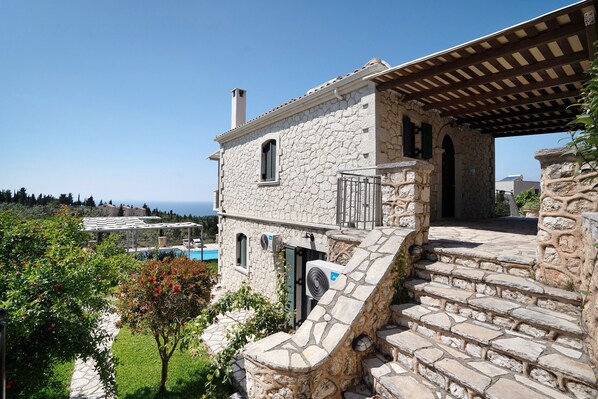 A stone building with a covered porch, a pool, and a view of the sea. - "Villa Nefeli" with Sea View, Private Pool & Wi-Fi (Lefkada)