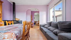 A dining area with a table, chairs, and a sofa. - Holiday Home "de l'avi" with Pool, Garden & Wi-Fi (Camarles)