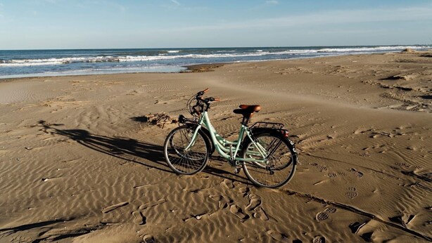 A bicycle on a sandy beach with footprints and a clear sky. - Holiday Home "de l'avi" with Pool, Garden & Wi-Fi (Camarles)