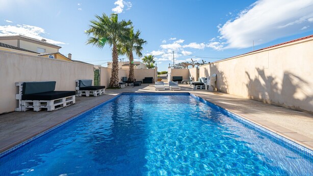 A swimming pool with lounge chairs, palm trees, and a clear sky. - Holiday Home "La Marquesa" with Shared Pool, Garden & Wi-Fi (Camarles)