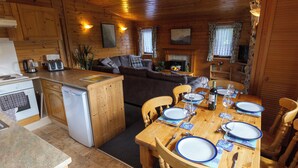 A cozy cabin interior with a dining area, kitchen, and living space. - Whiteside Lodge at Burnside Park (Keswick)