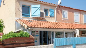 A building with a tiled roof, multiple windows with shutters, and a satellite dish. - 2-Star Apartment "Chez Domi résidence front de mer" with Terraces & Wi-Fi (Frontignan)