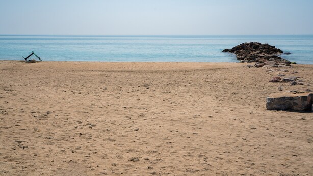 A beach with a clear sky, a sandy shore, and a rocky outcrop in the water. - 2-Star Apartment "Chez Domi résidence front de mer" with Terraces & Wi-Fi (Frontignan)