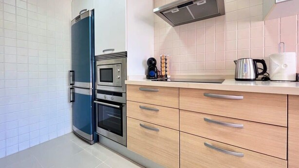 Eine moderne Küche mit Einbauofen, Mikrowelle und einem Doppel-Kühlschrank.