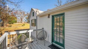 A white house with a green door and a porch with two chairs and a table. - Private 1BR Cottage In Downtown Historic Norcross (Norcross)