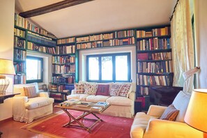 Un salon chaleureux avec un canapé, une table basse et une bibliothèque remplie de livres.